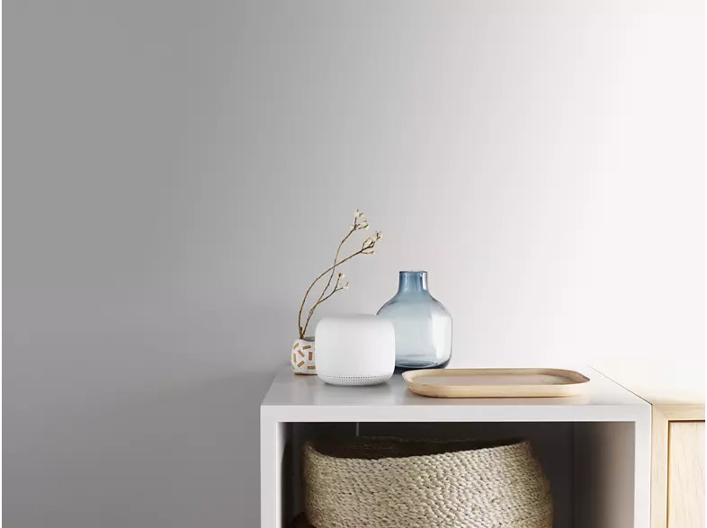 Étagère blanche avec des objets : un vase, une plante et un plateau.