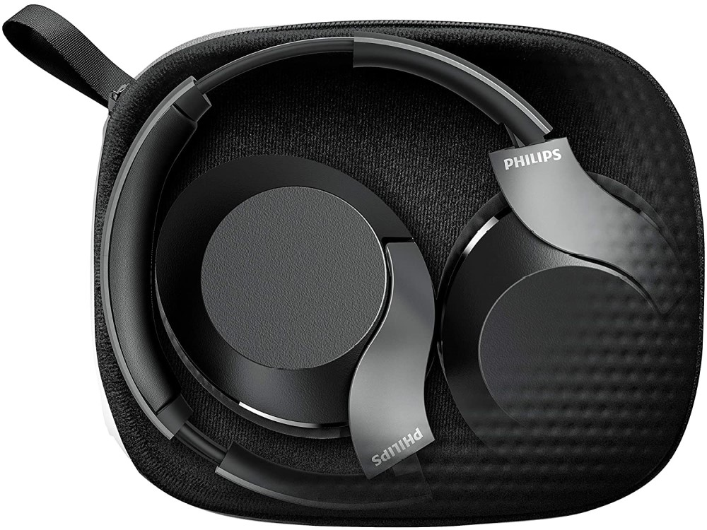 Auriculares Philips negros y plegados dentro de un estuche negro. El estuche está sobre un fondo blanco.