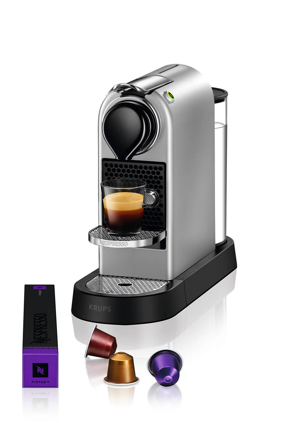 Silberne Nespresso-Kaffeemaschine mit Tasse, Kapseln und Nespresso-Box.