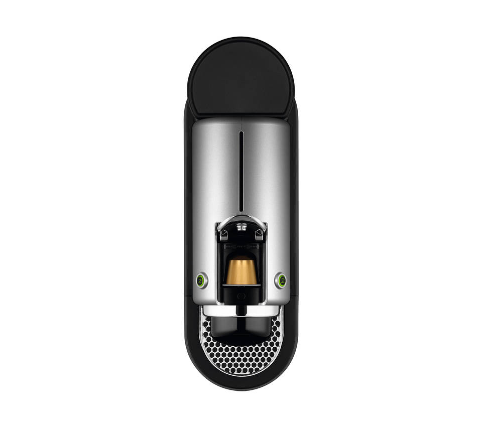 Eine schwarze und silberne Nespresso-Kaffeemaschine, Draufsicht, auf Weiß.