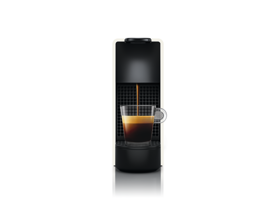 Espressomaschine, schwarz, gießt Kaffee in ein klares Glas. Schwarzer Hintergrund.