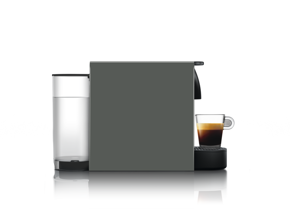 Nespresso-Kaffeemaschine mit einem Glas Wasser und einer Tasse Espresso auf schwarzem Untergrund.