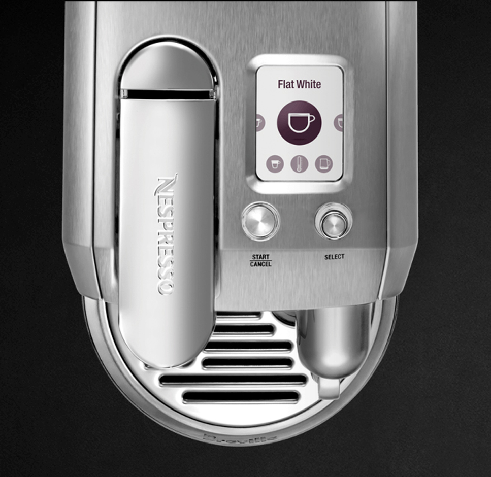 Silberne Nespresso-Maschine mit Touchscreen. Zeigt Flat White. Knöpfe und eine Abtropfschale.