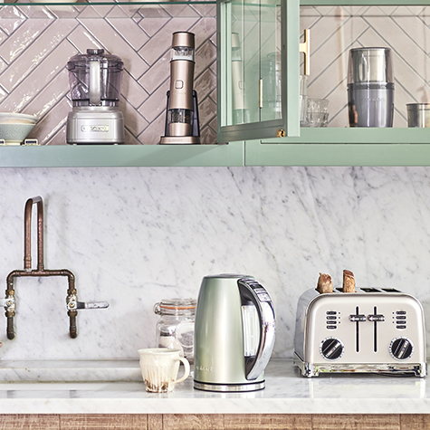 Kitchen countertop with appliances: kettle, toaster, and food processor.