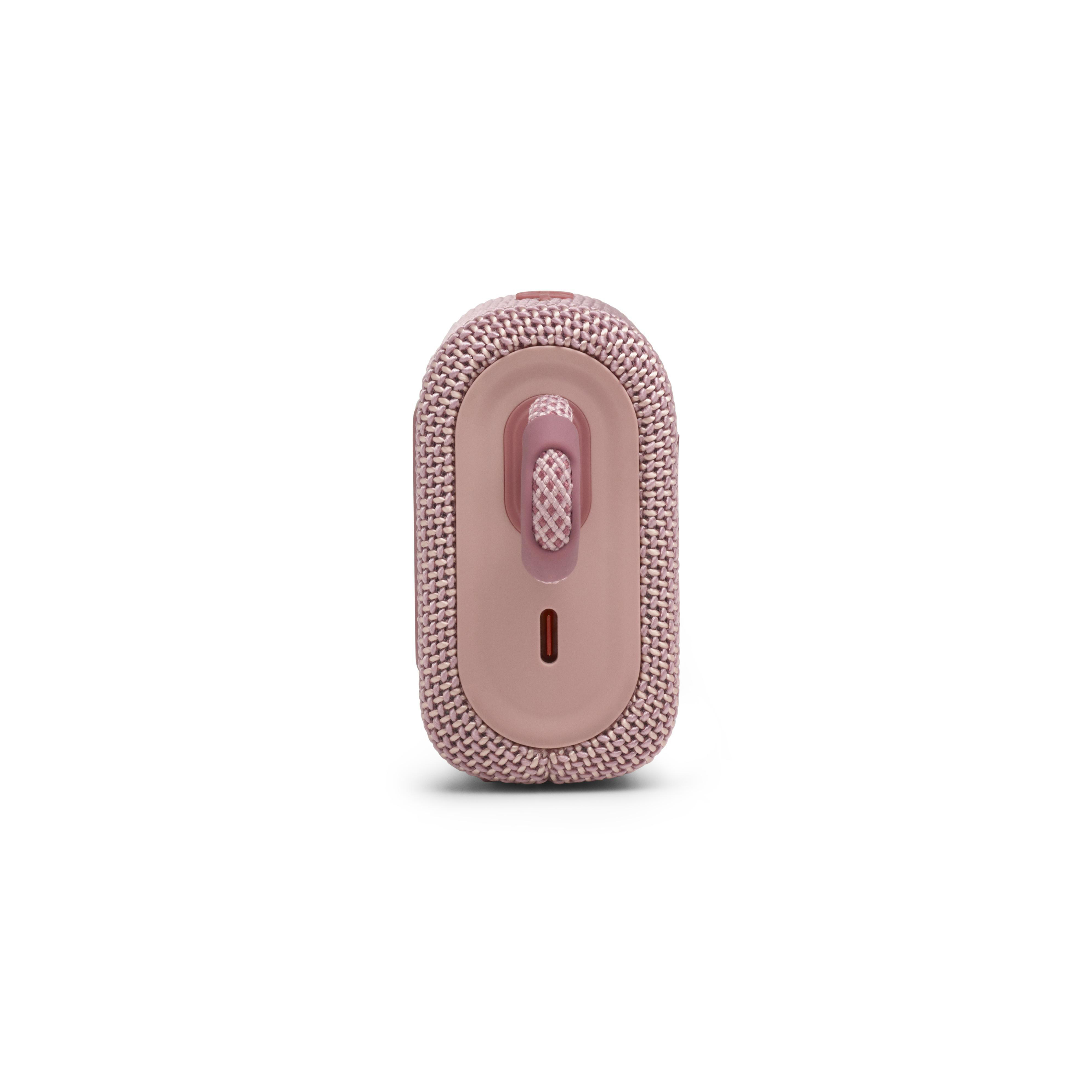 Ein rosa Lautsprecher, vertikal, mit rosa Riemen und Ladeanschluss auf Weiß.