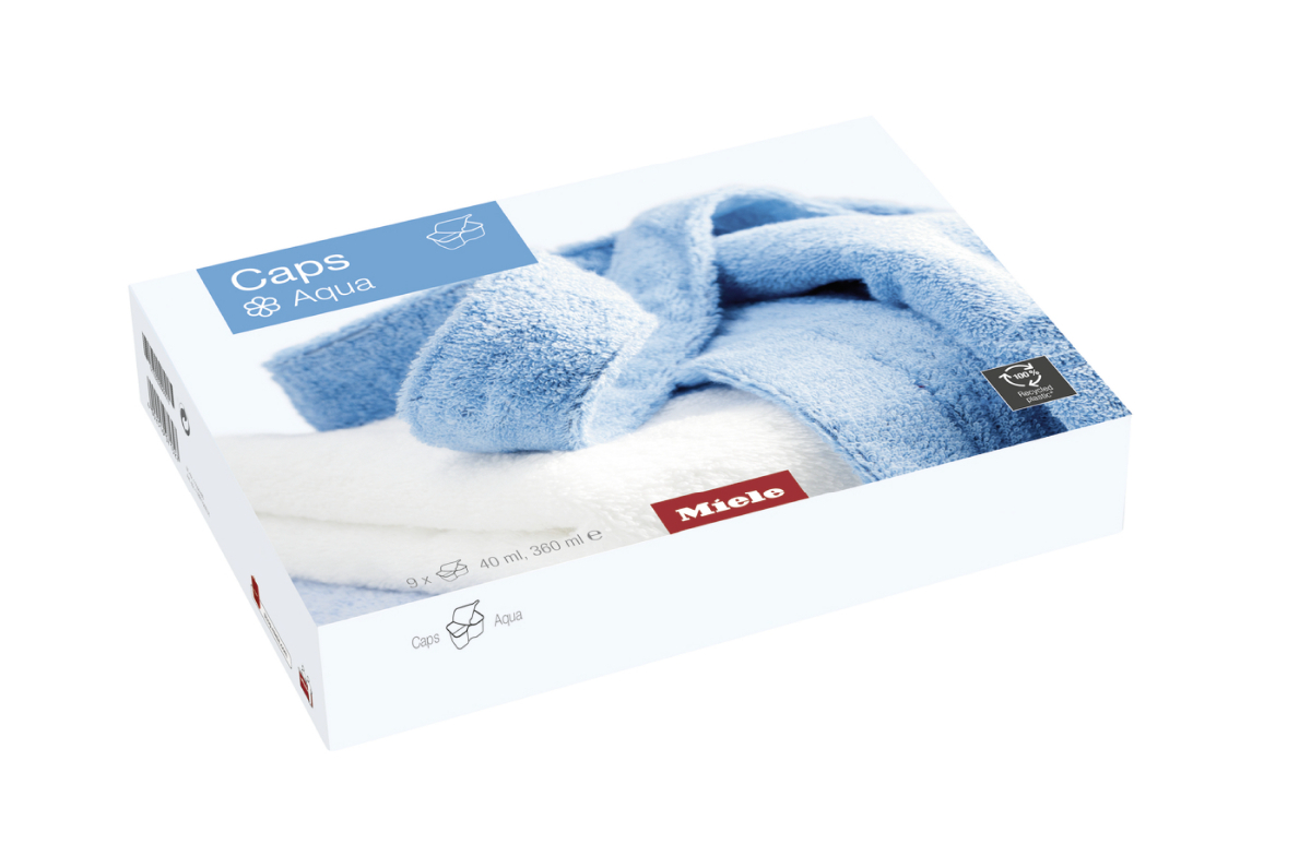 Boîte de capsules de détergent bleues Miele. Une serviette est dans la boîte. Fond blanc.