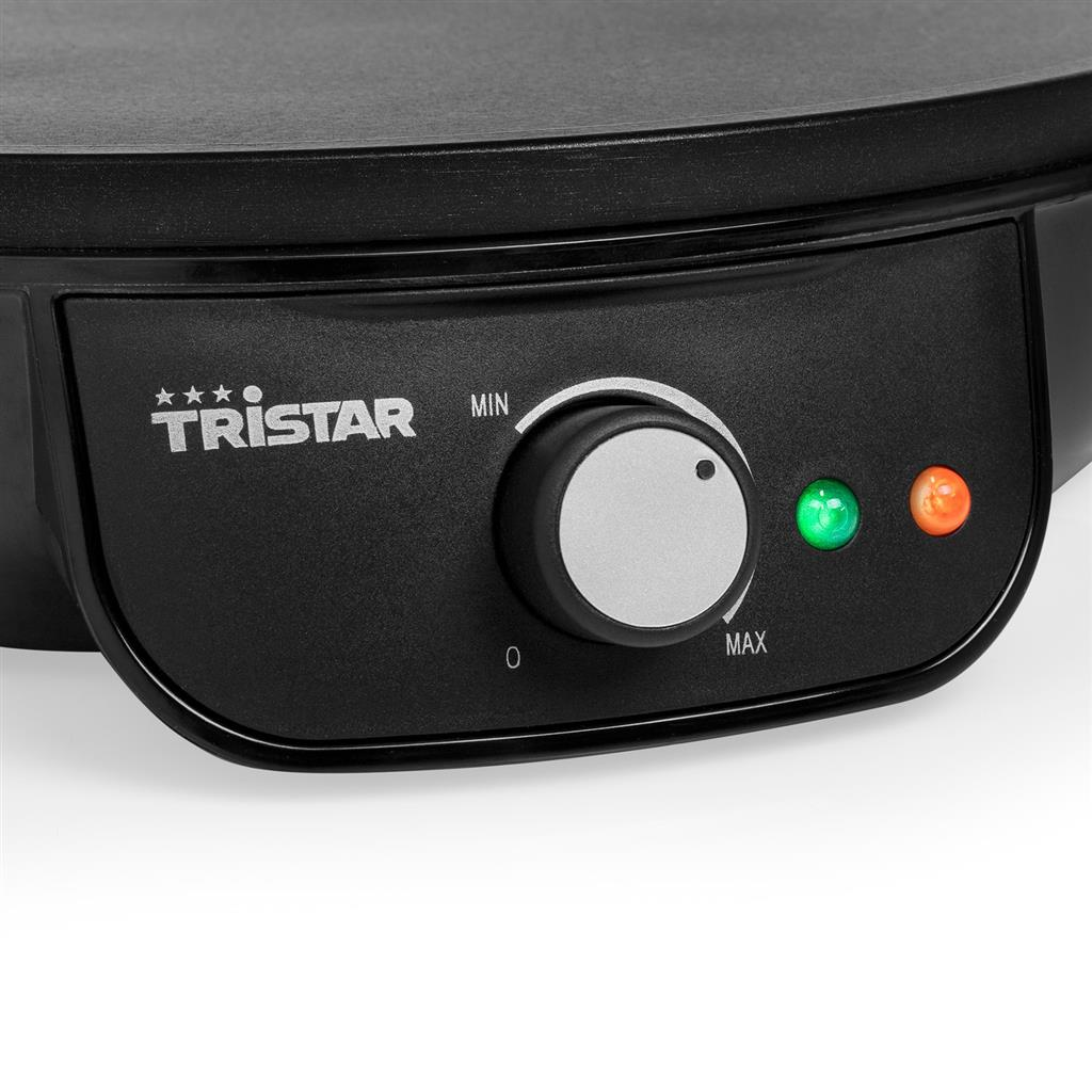Ein schwarzes Bedienfeld mit Drehknopf, grünem Licht und orangem Licht. Die Marke ist Tristar.