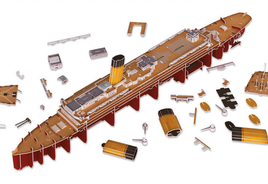 Ein Modell der Titanic ist auf weißem Hintergrund auseinandergenommen, mit verstreuten Teilen.