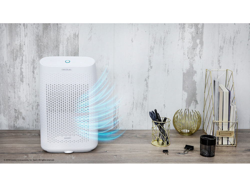 Purificador de aire blanco con flujo de aire. Varios artículos sobre una superficie de madera.