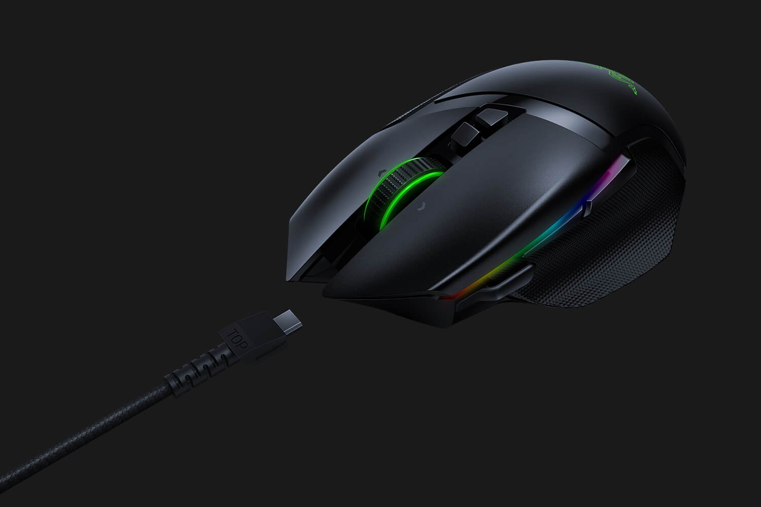 Zwarte gamingmuis met een groen scrollwiel en RGB-verlichting. Verbonden met een USB-kabel. Donkere achtergrond.