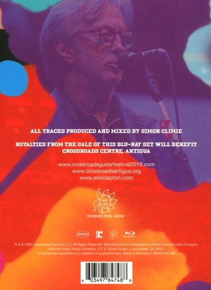 Egy DVD tok hátulja, amely Eric Clapton Antigua-i Crossroads Centeréről szóló szöveget mutatja. Piros és narancssárga árnyalatok.