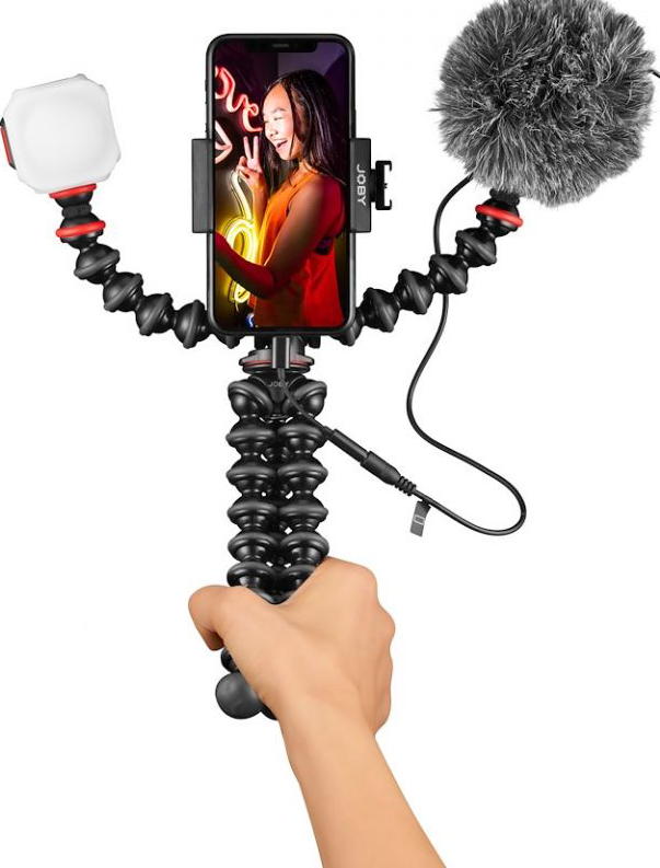 Eine Person hält ein Telefon, das an einem Stativ mit Lichtern und Mikrofon befestigt ist.