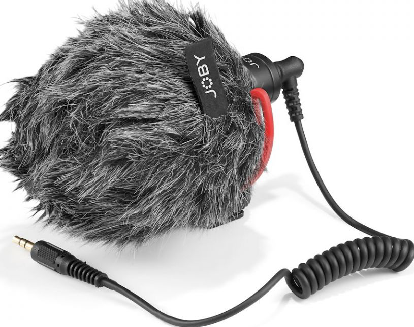 Petit microphone noir avec housse en fourrure grise, fil spiralé, prise noire.