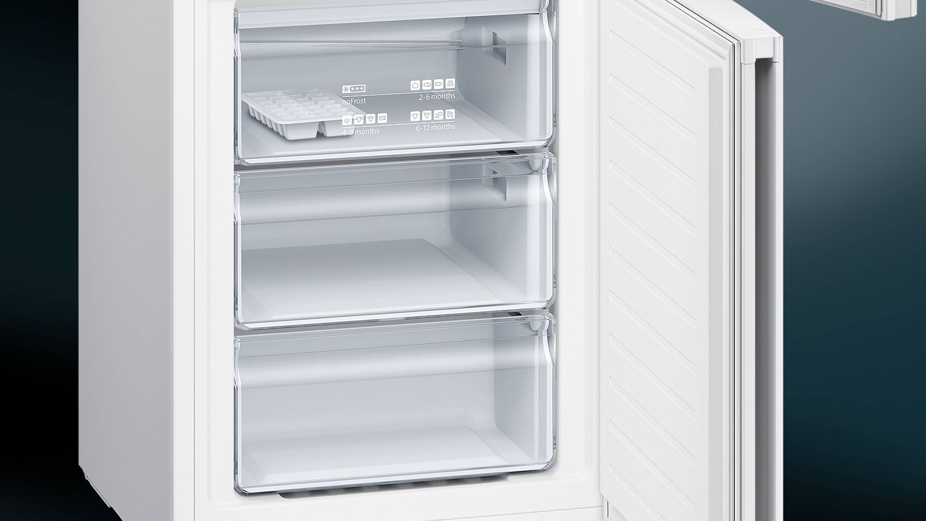 Interior de refrigerador blanco con cajones de congelador abiertos. Tres cajones visibles. Etiquetas visibles.