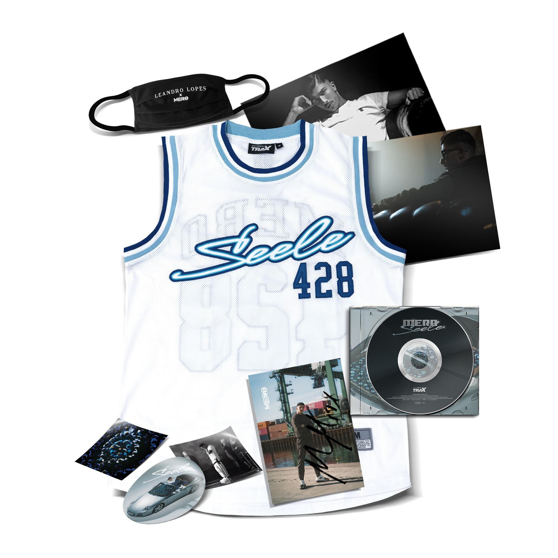 Sporttrikot, Fotos, eine CD und eine Maske sind auf einer weißen Oberfläche angeordnet.