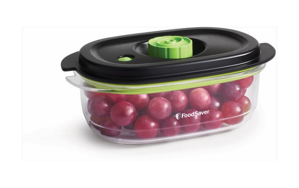 Un recipiente transparente contiene uvas rojas, sellado con una tapa negra y un cierre verde.