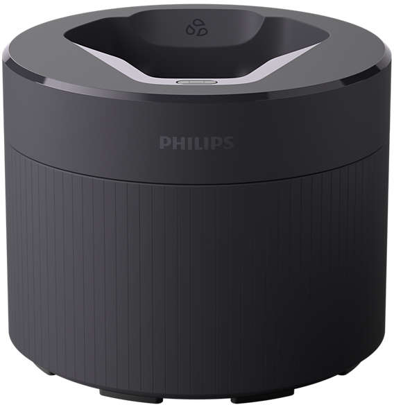 Black Philips speaker charging dock. It is a round cylinder with a white top.