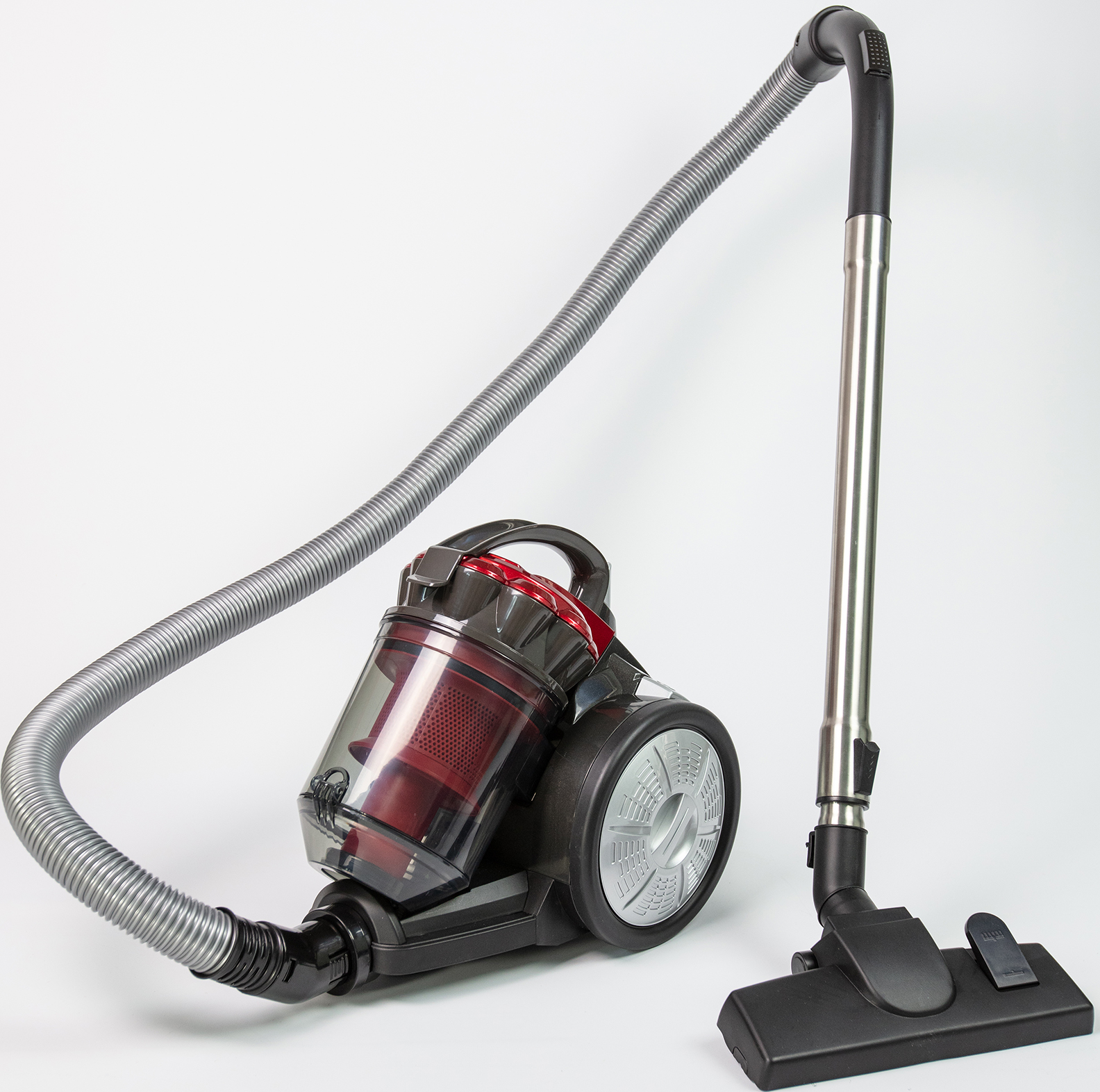 Un aspirateur rouge et noir avec un conteneur à poussière transparent et un tuyau.