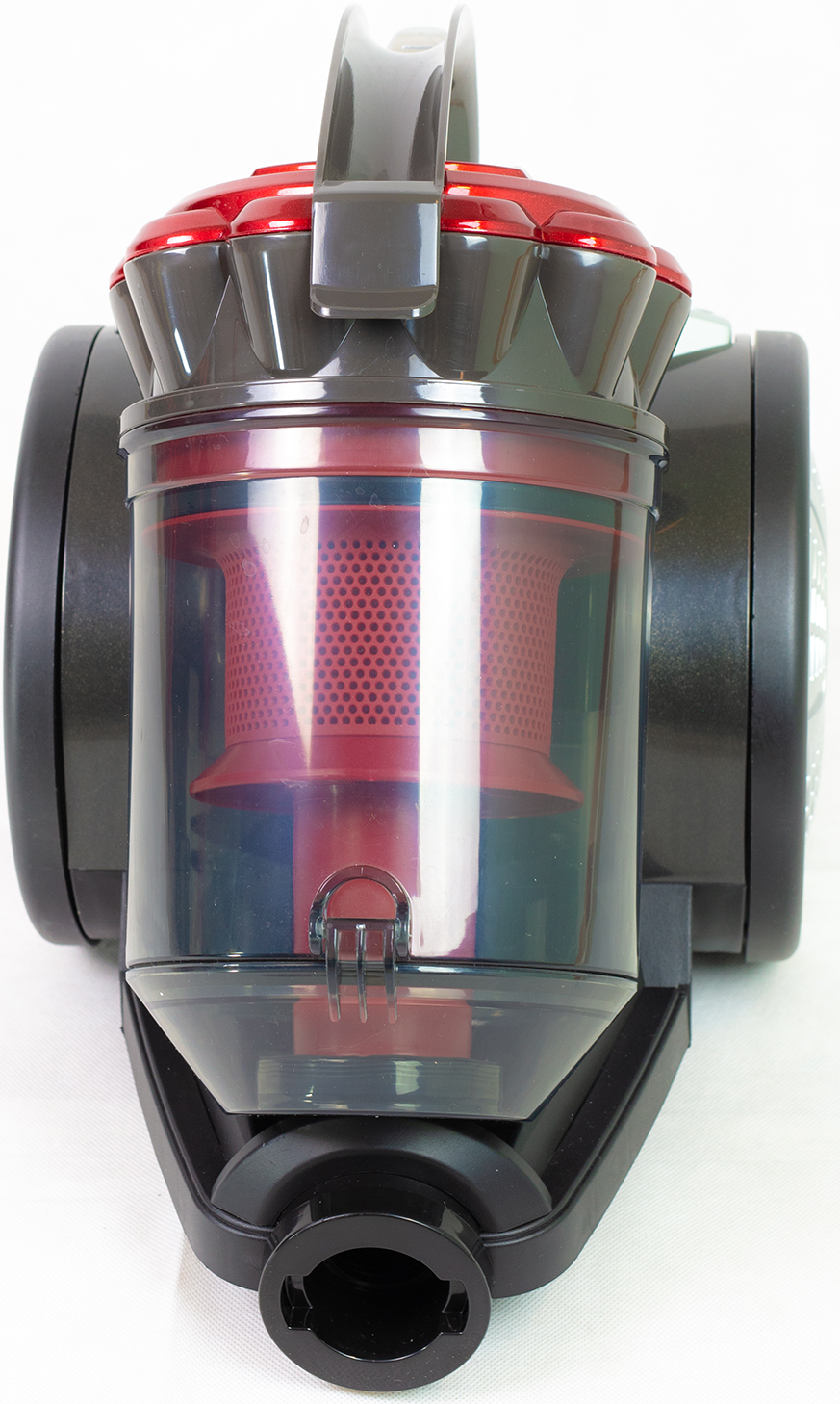 Gros plan d'un aspirateur, avec un récipient transparent montrant un filtre rouge.