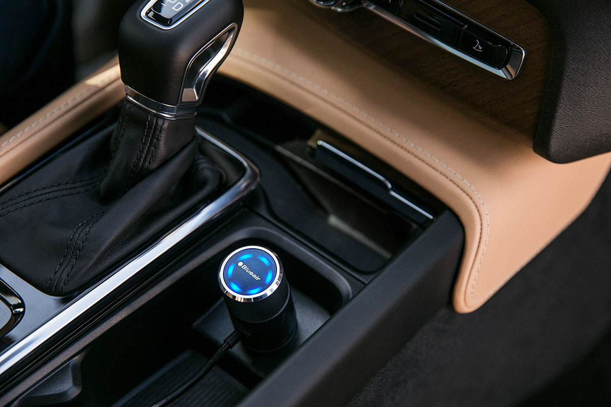 A car interior with a Blueair car air purifier in the console.