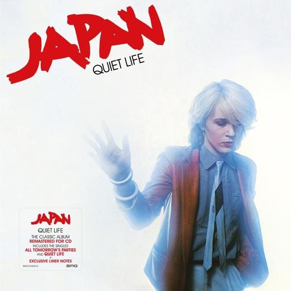 Pochette d'album de JAPAN, un homme en costume, fond blanc, texte JAPAN rouge, autocollant.