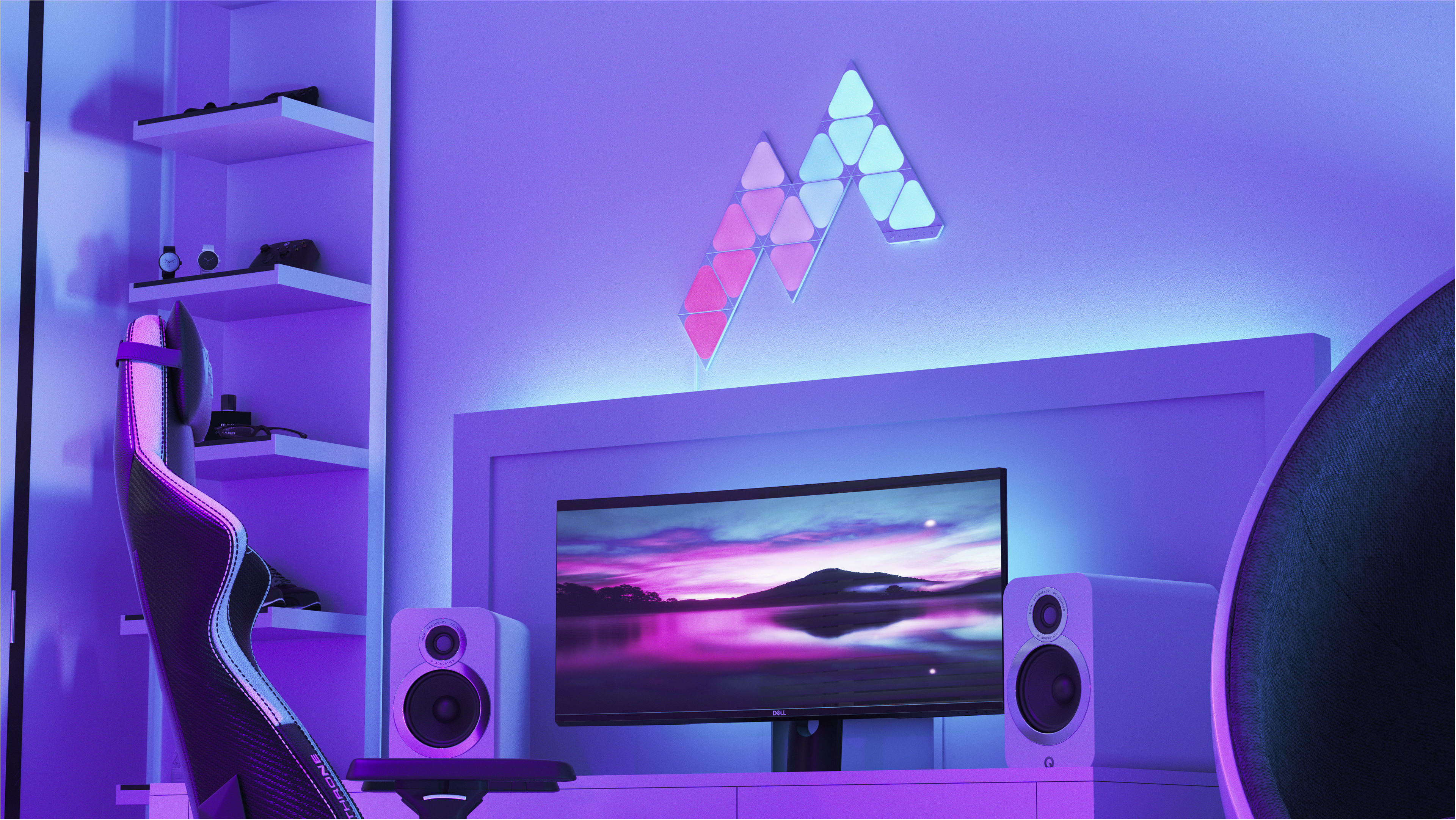 Zimmer mit Gaming-Setup. Wandleuchten, Monitor, Lautsprecher und Gaming-Stuhl.