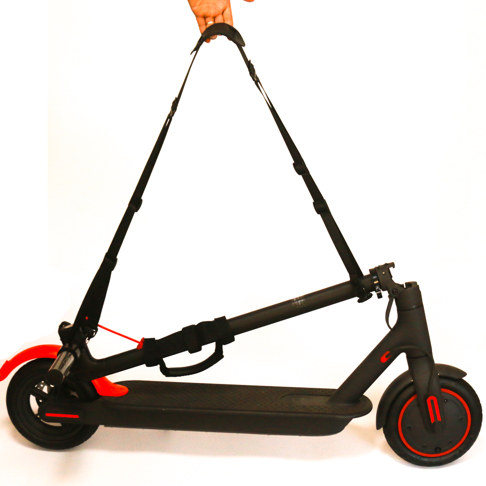 Patinete eléctrico plegable negro y rojo. Correa negra en la parte superior.