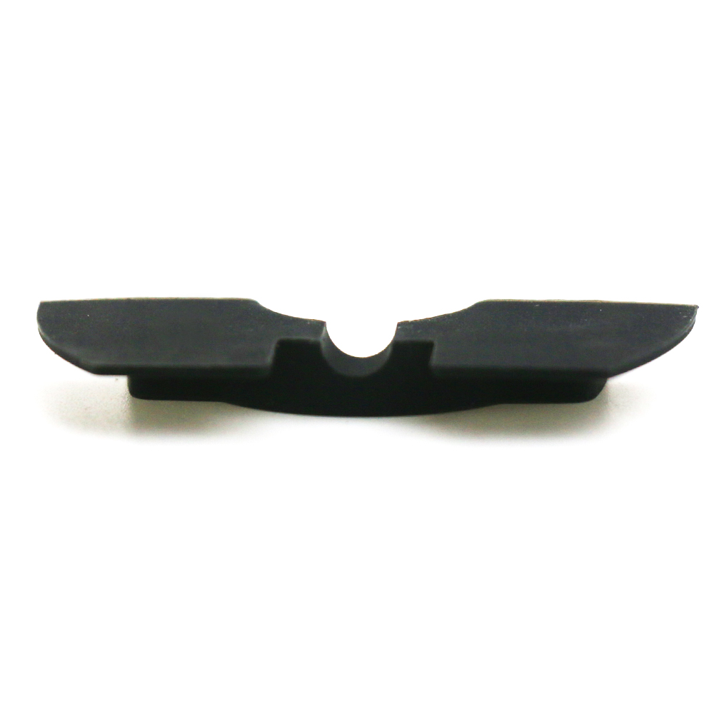 Un pequeño componente de goma negro. Tiene una forma curva con una ranura central poco profunda.