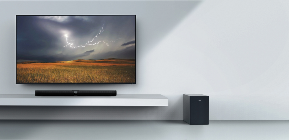 Sala de estar con TV, barra de sonido y subwoofer. Tormenta eléctrica en pantalla.