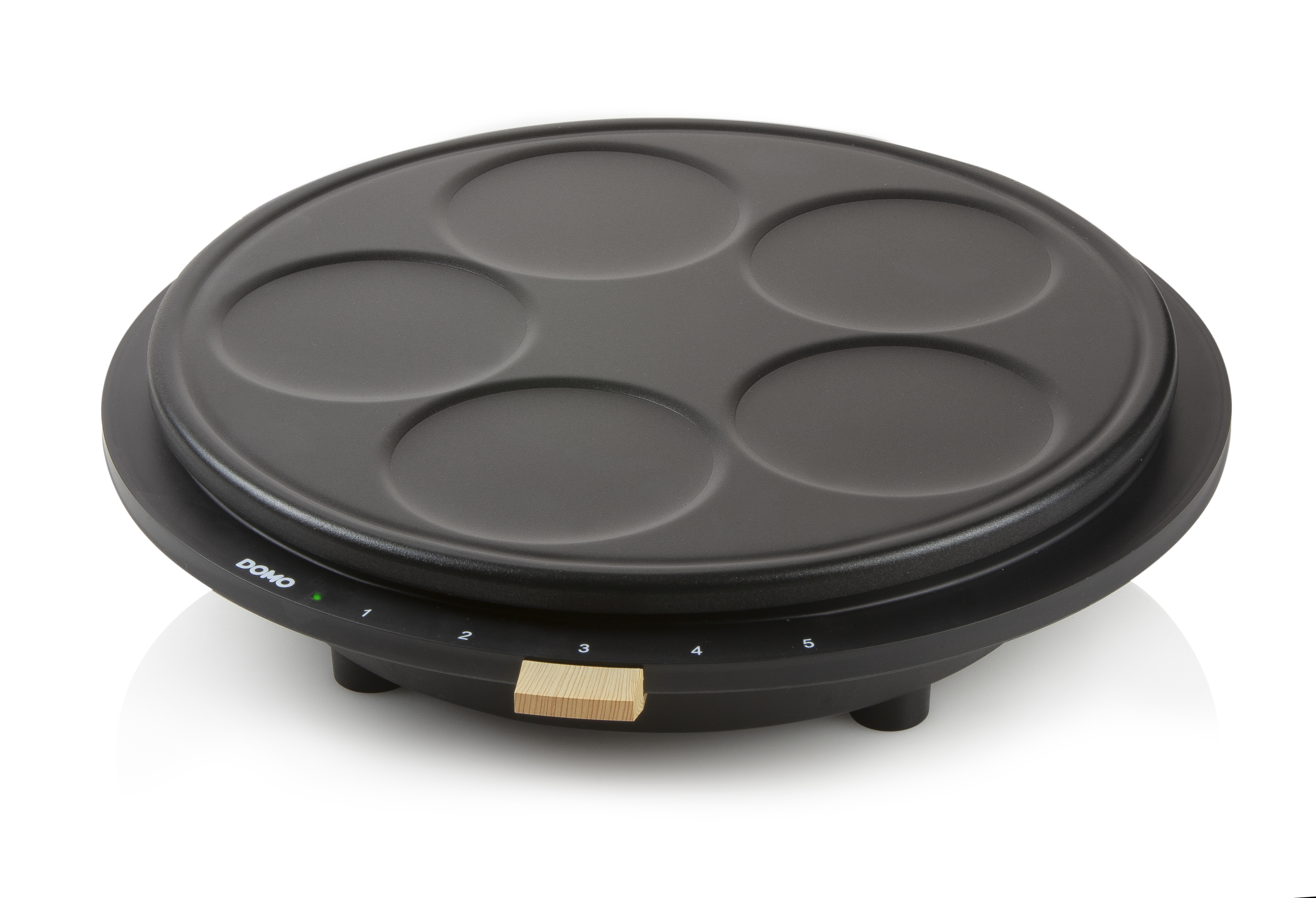 Black pancake maker with five circular molds, on a white background.