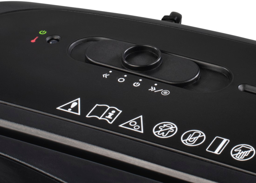 Close up of a black paper shredder with buttons and warning icons on top.