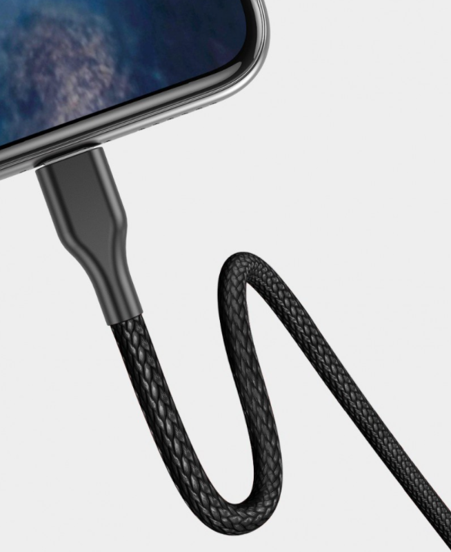 Fekete fonott USB-C kábel egy telefonhoz csatlakoztatva. A kábel ívelt.