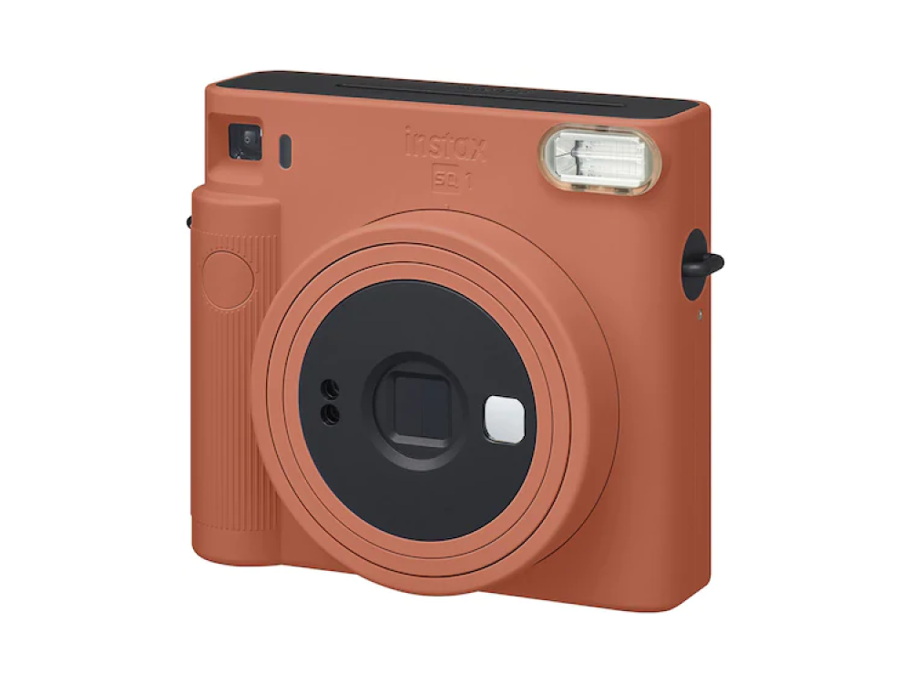 Cámara Instax naranja con lente y flash negros. Fondo blanco.