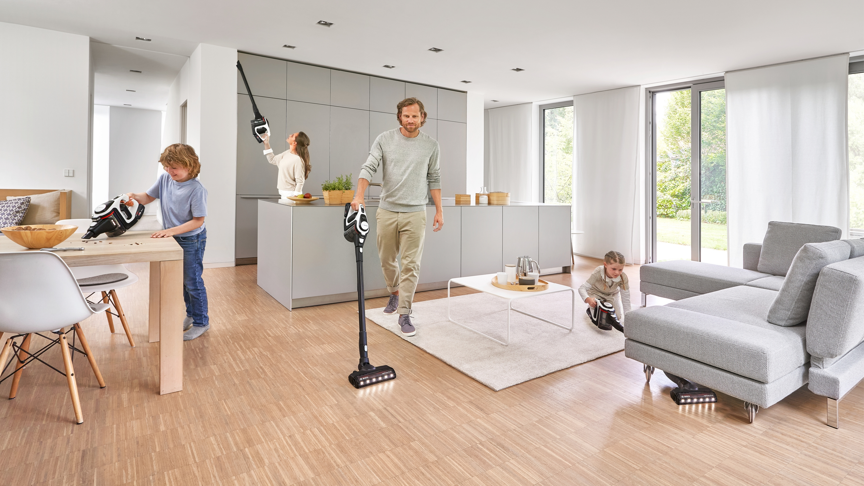 Eine Familie putzt ein Haus. Ein Mann geht mit einem Staubsauger, und Kinder benutzen Staubsauger.