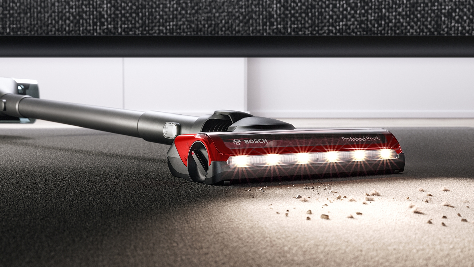 Nahaufnahme eines Staubsaugerkopfes auf Teppich, Lichter an, Marke Bosch.
