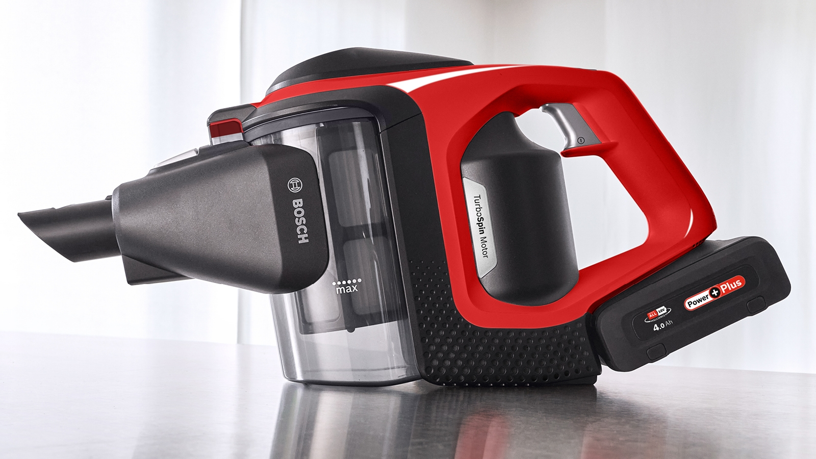 Ein kabelloser Staubsauger. Er ist rot und schwarz, mit einem Akku. Der Hintergrund ist weiß.