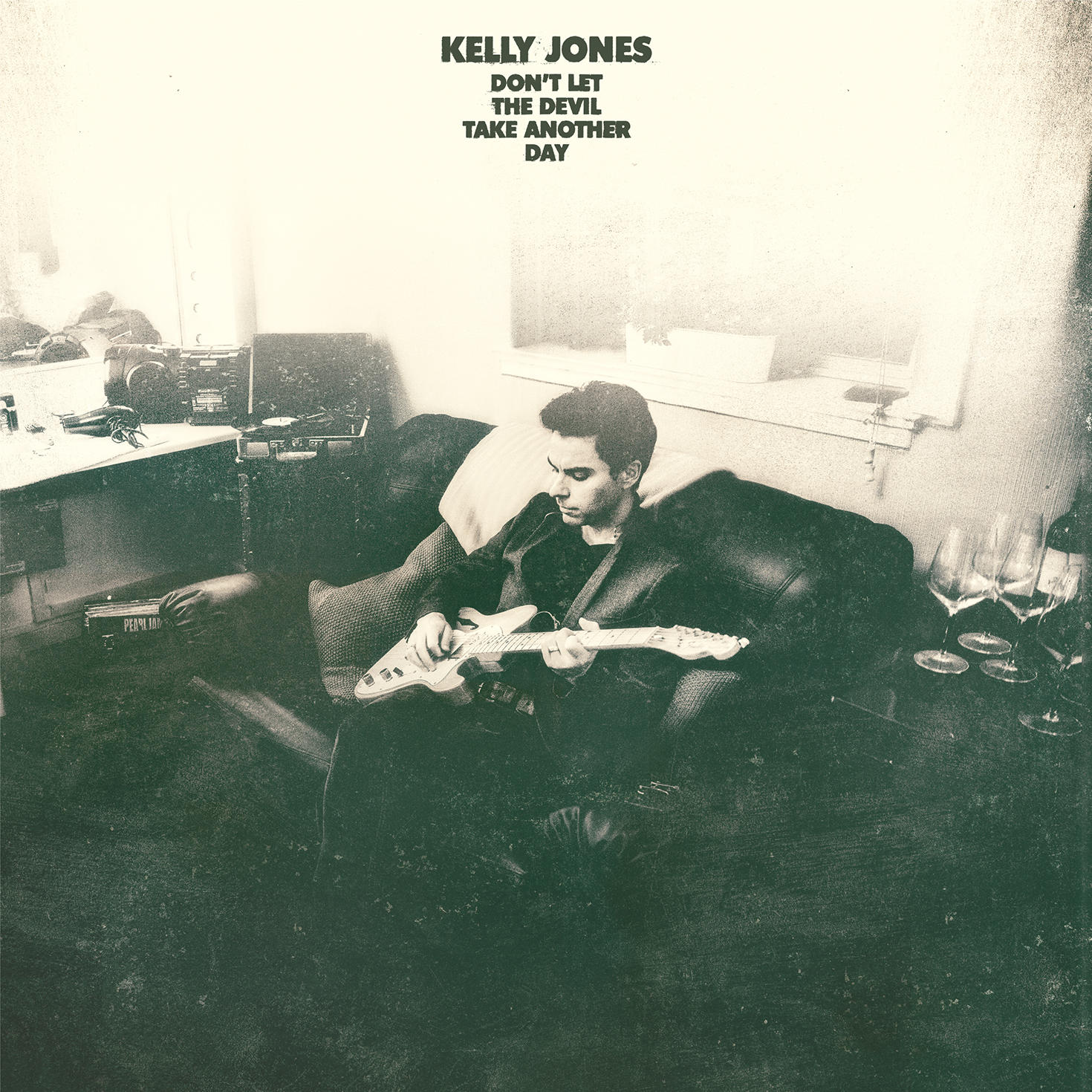 Albumborító. Egy gitáros férfi ül a kanapén. Cím: Kelly Jones, Don't Let the Devil Take Another Day.