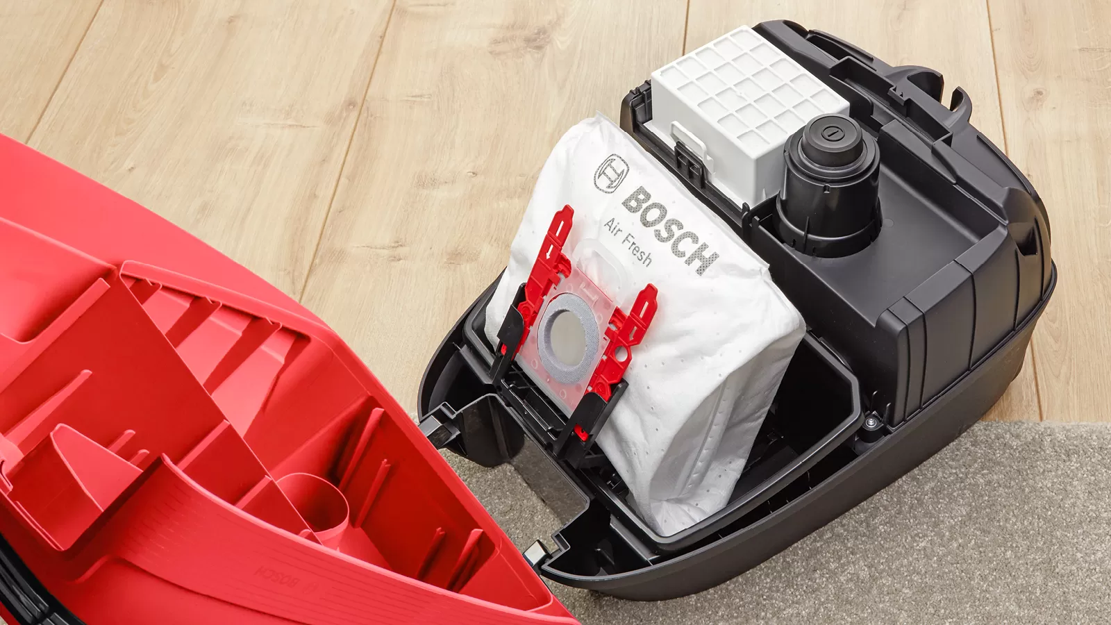 Geöffneter Staubsauger mit weißem Bosch Air Fresh Beutel, rotes Gehäuse.