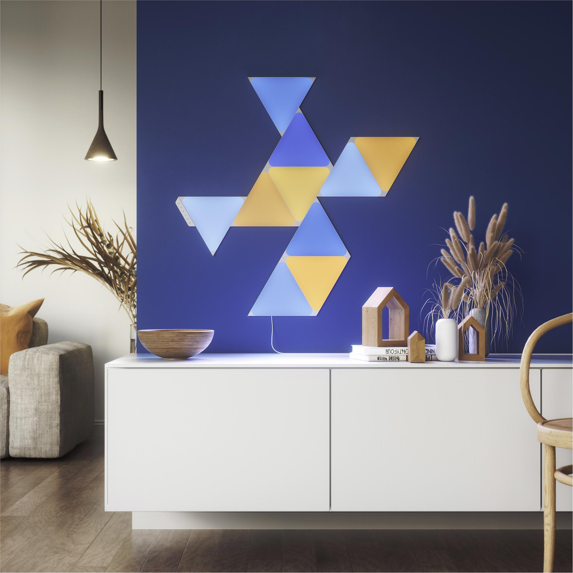 Wanddekor mit geometrischen Lichtpaneelen in Plusform, an einer blauen Wand und weißem Schrank.