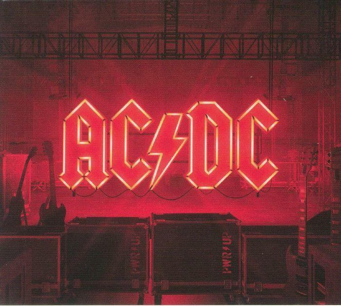 AC/DC neonfelirat a zenekar logójával piros színben, színpadi berendezés felett.