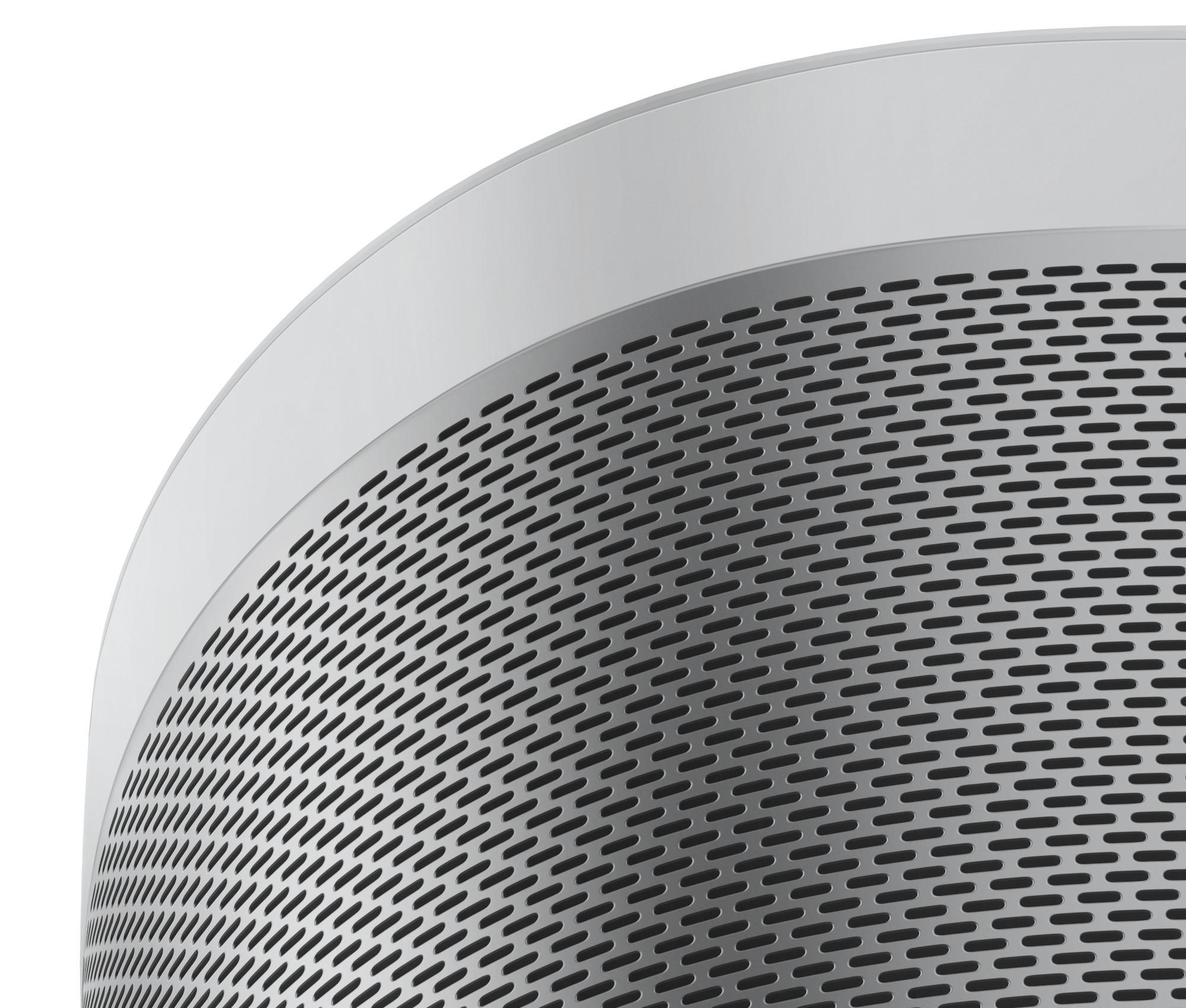 Nahaufnahme eines silbernen Lautsprechergrills mit vielen kleinen Löchern und gebogener Oberkante.