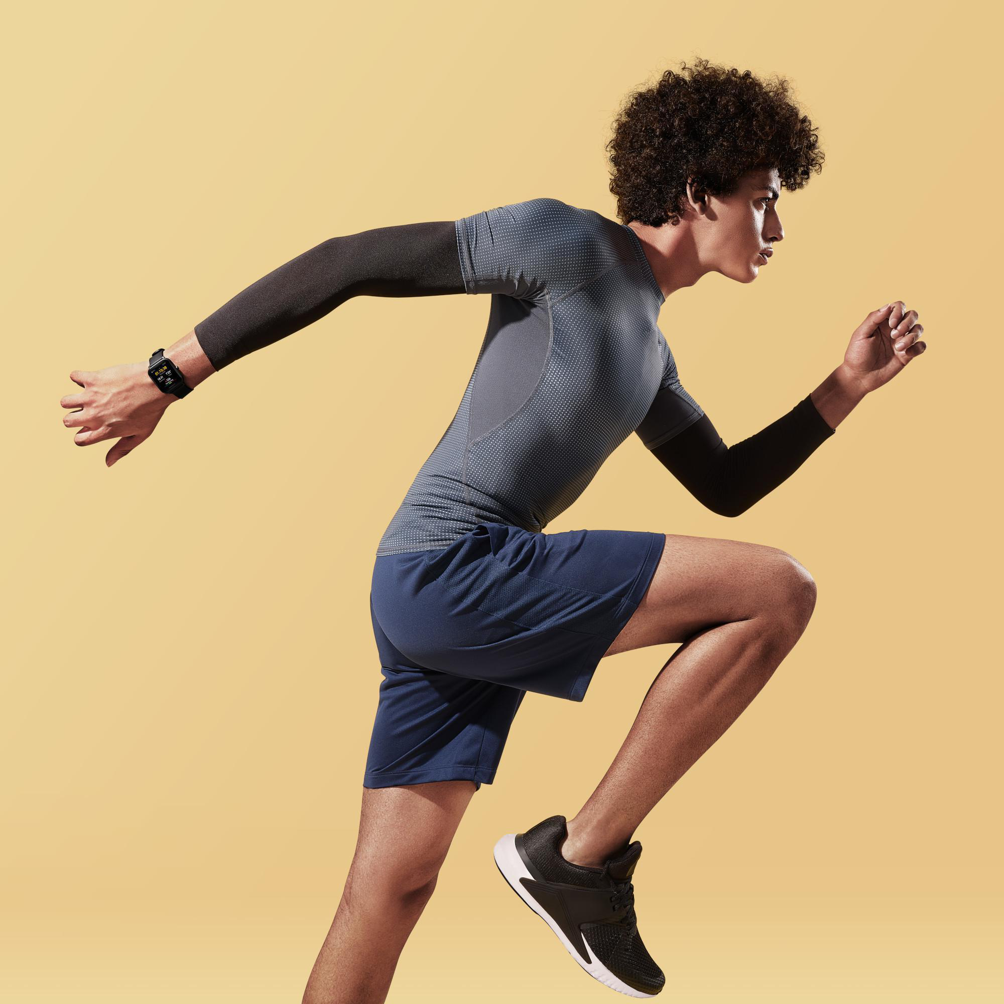 Mann rennt in Sportkleidung vor gelbem Hintergrund.
