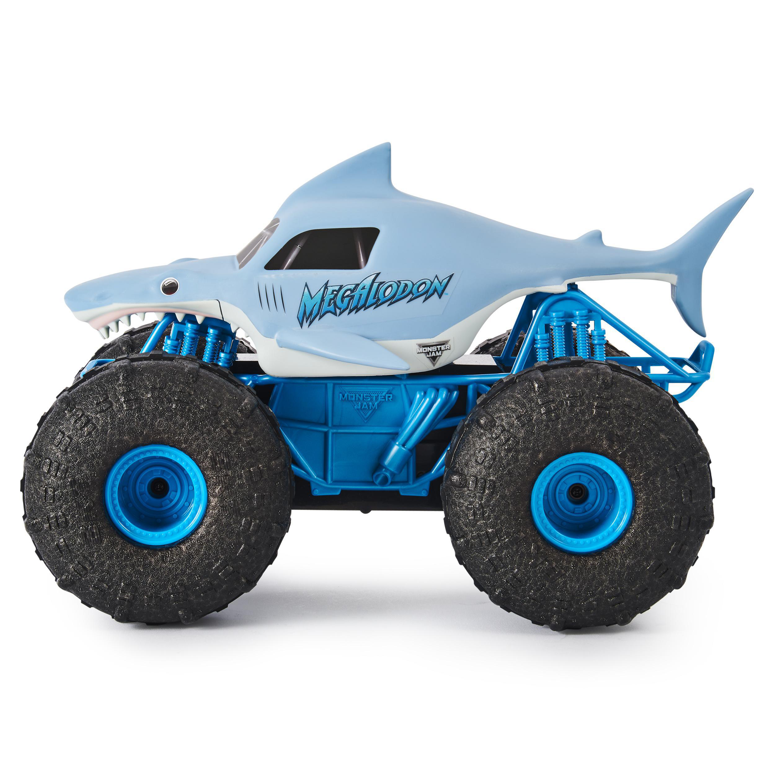 Spielzeug-Monstertruck, haiförmig, blau und weiß, mit großen schwarzen Reifen, auf weißer Oberfläche.