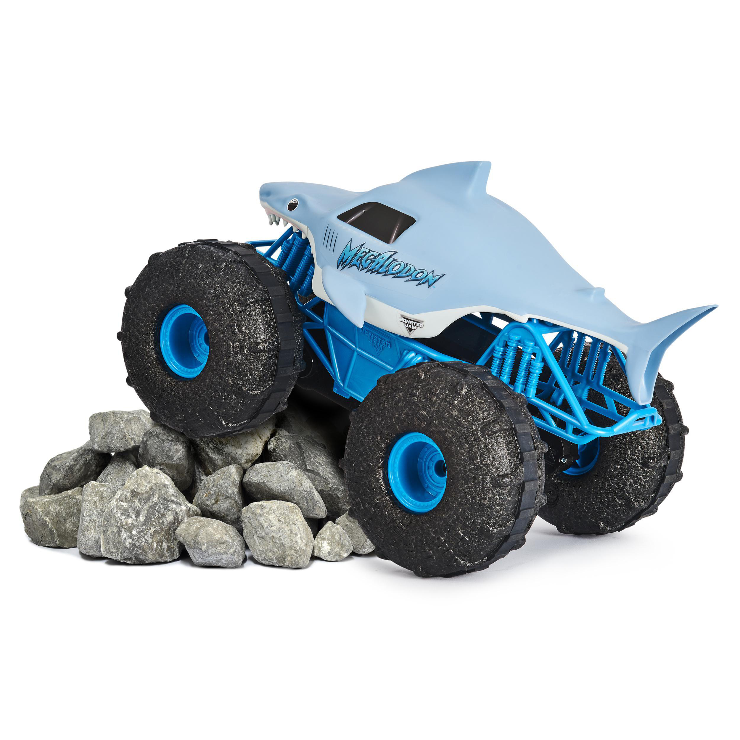 Ein Spielzeug-Monstertruck mit Hai-Design, auf einem Haufen grauer Steine.