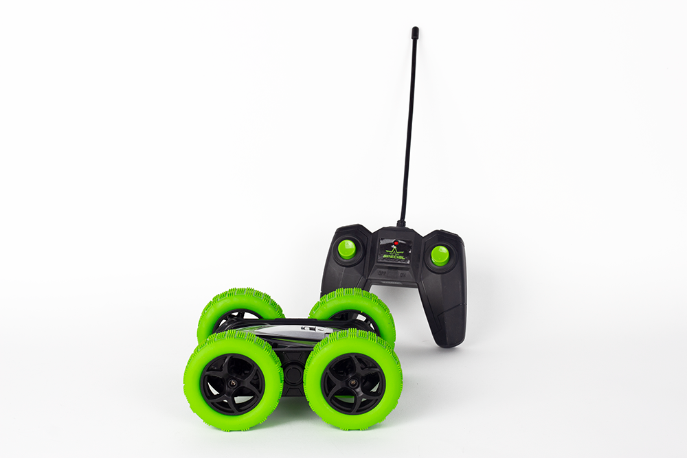 Afstandsbediening auto met groene wielen, zwarte carrosserie en antenne. Witte achtergrond.