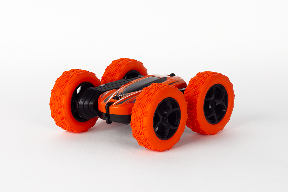 Orange and black remote control car on a white surface. The car has large orange wheels.
