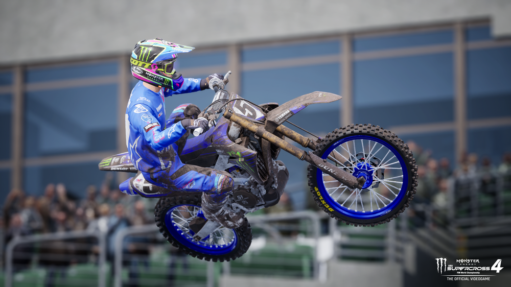 Un corredor de motocross en el aire en una moto de cross en un estadio.