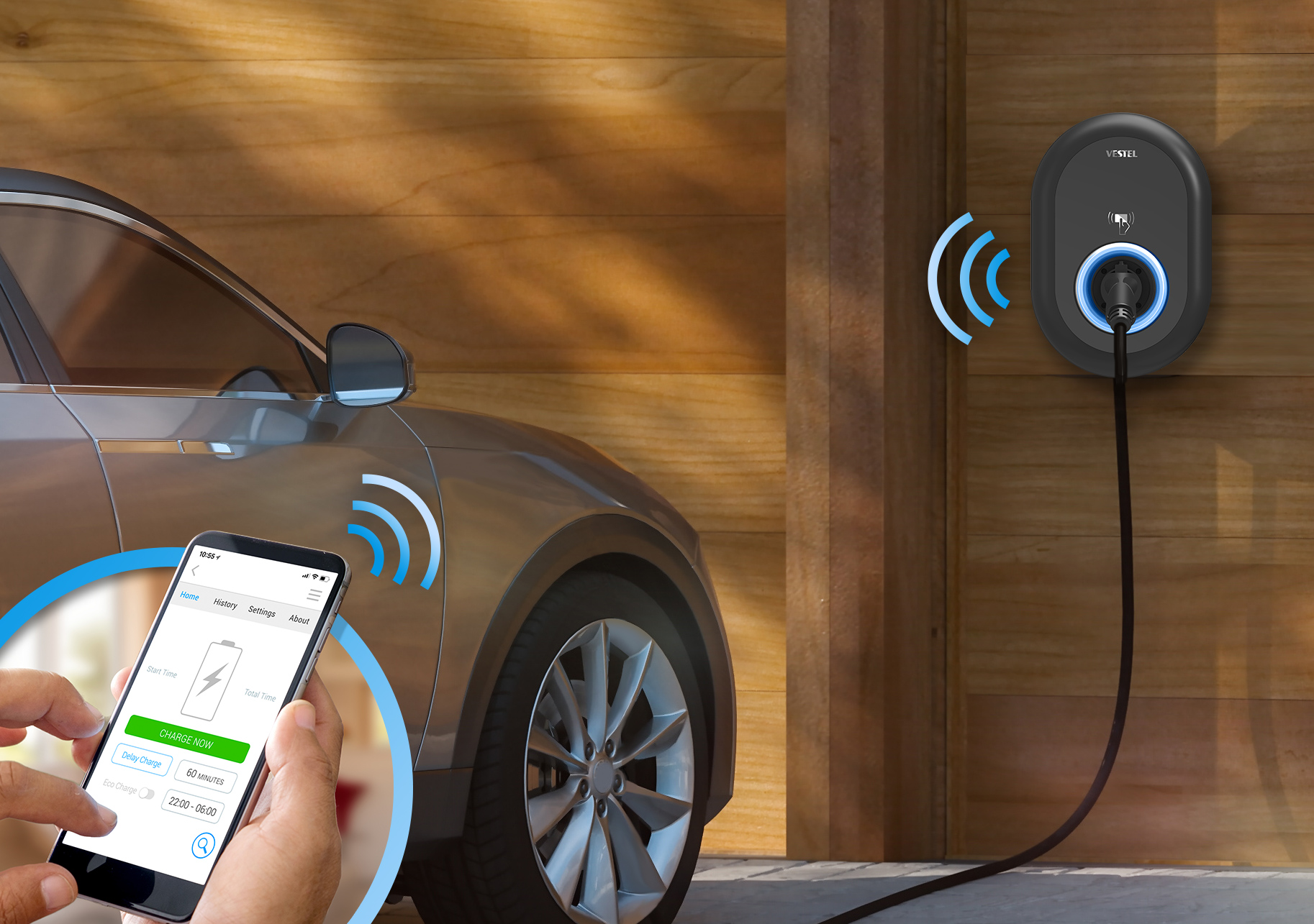 Ein Elektroauto, das an einer Hausladestation geladen wird. Der Telefonbildschirm zeigt Ladeoptionen mit der Hand einer Person.