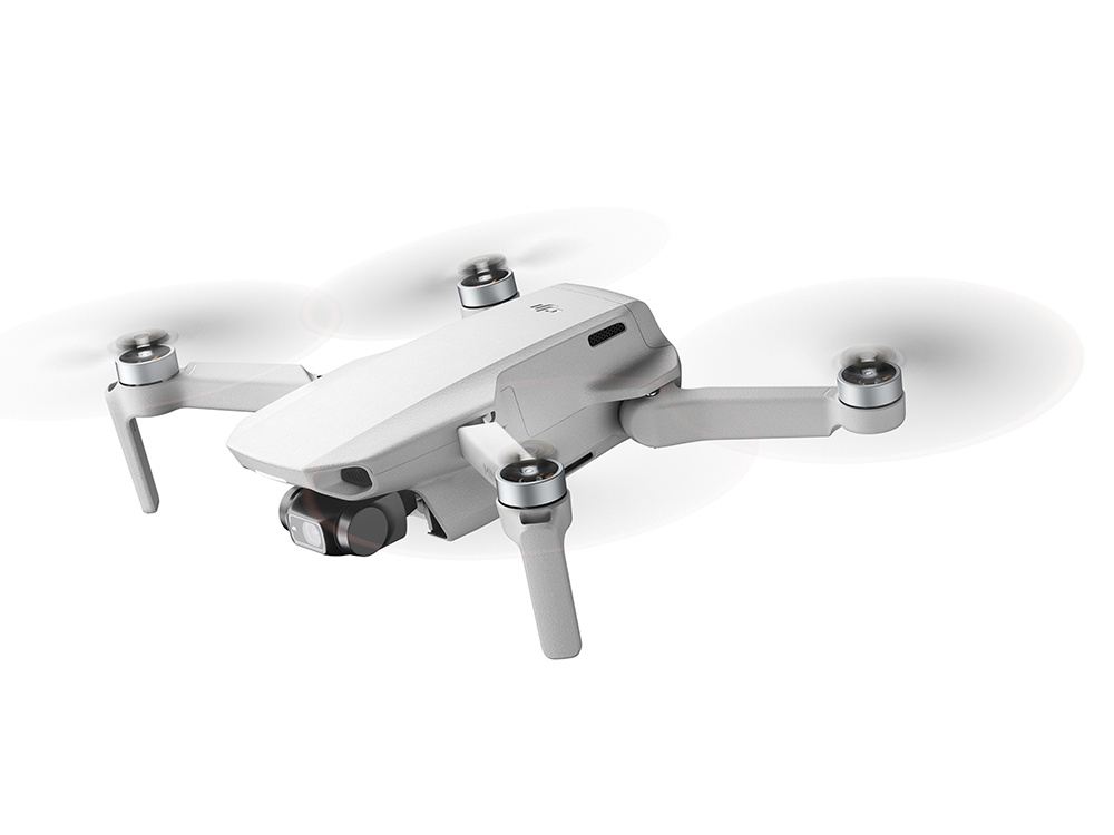 Un dron blanco flotando. Tiene cuatro hélices y una cámara. Fondo blanco.