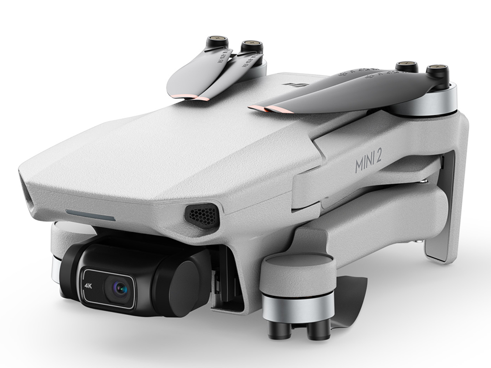 Un dron blanco con hélices grises y una cámara negra. Está sobre un fondo blanco.